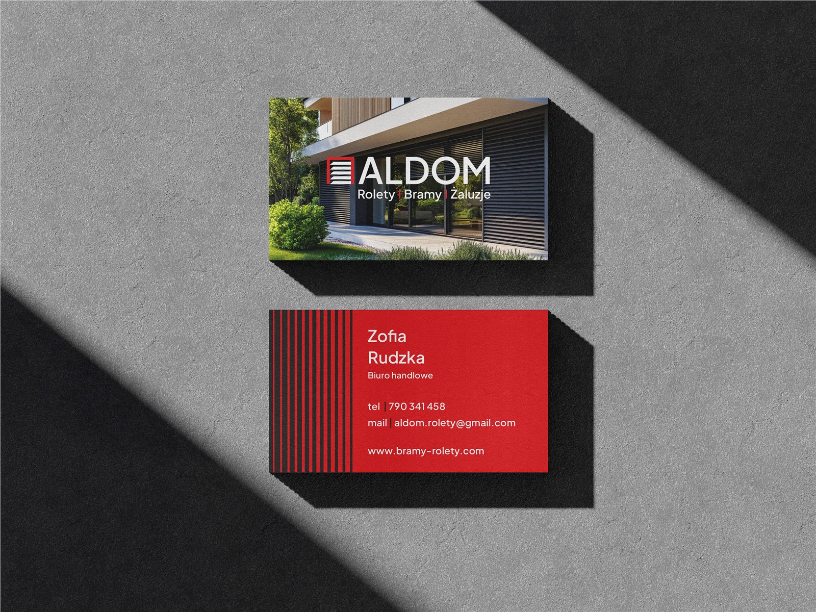 Wizytówka firmowa Aldom z&nbsp;logotypem na tle nowoczesnej architektury z&nbsp;żaluzjami
